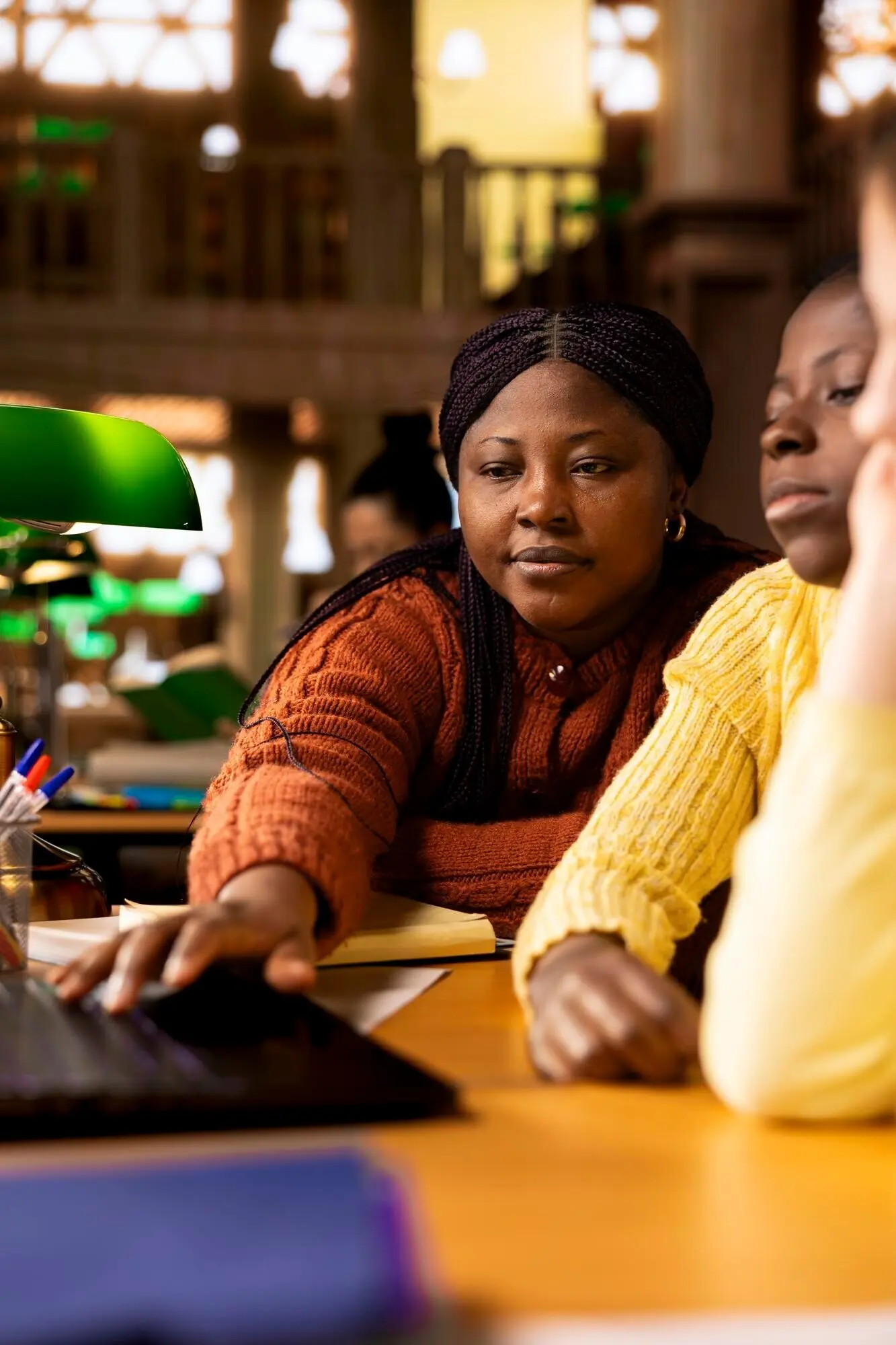 Zwei unterschiedliche Kinder arbeiten mit einem Tutor daran, Unterrichtsnotizen zu vervollständigen.